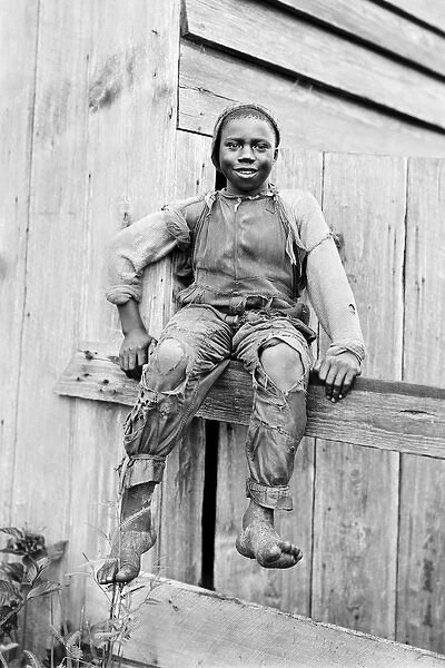 African-American boy sitting on a fence in America