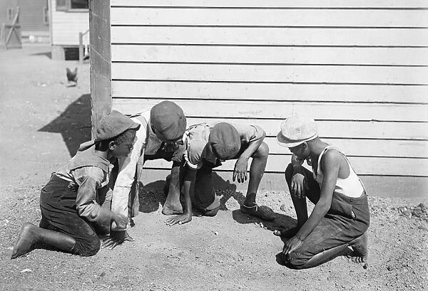 Four African American children playing a gambling game in Am