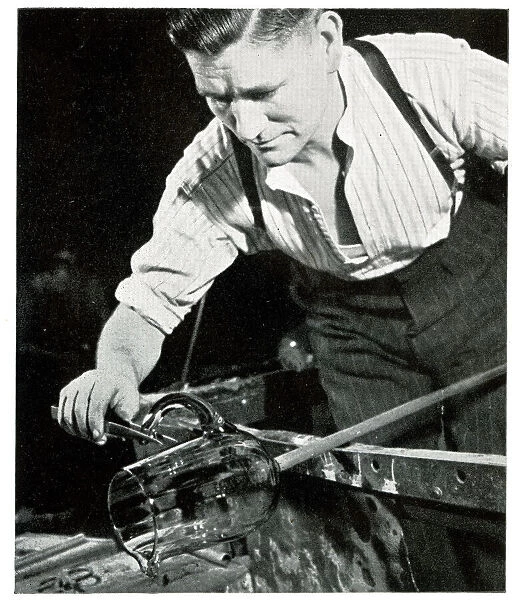 Glass blower fixing a handle on a jug