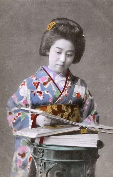 Japanese Geisha looking through a picture book