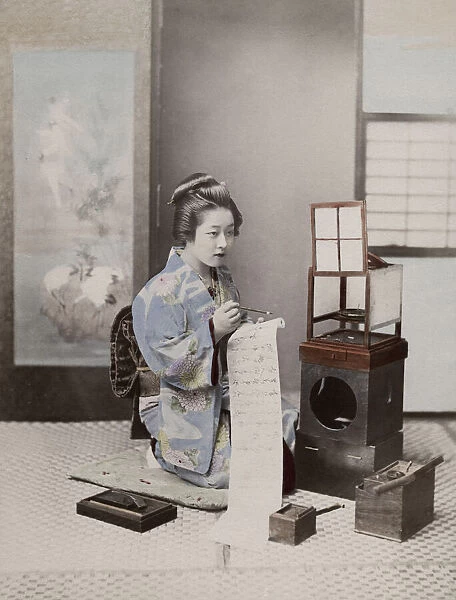 Japanese geisha in an ornate kimono writing a letter