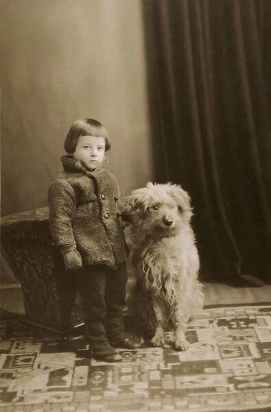 Little boy in his winter woollies and the family pet dog