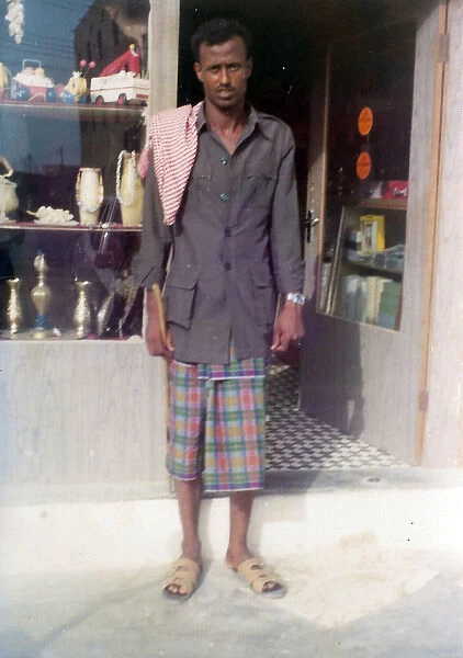 Omani man standing in front of a shop in Oman