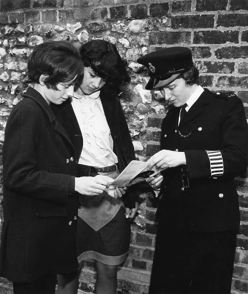 Woman police officer and two young women, London