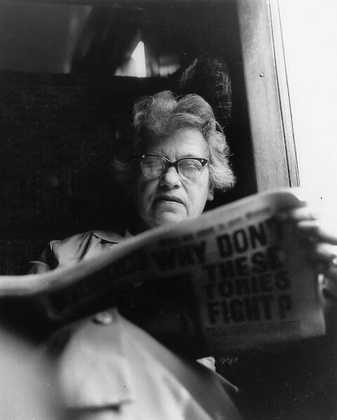Woman reading a newspaper on a train