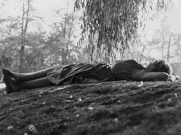 Woman relaxing on grass under a tree