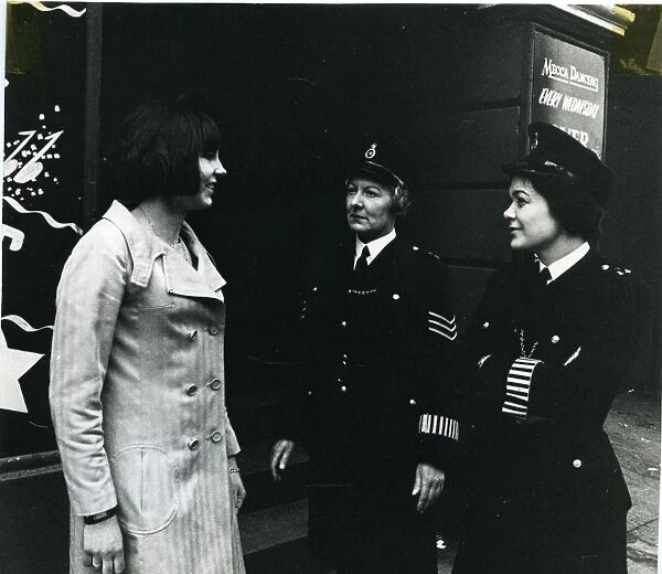 Two women police officers with woman on London street