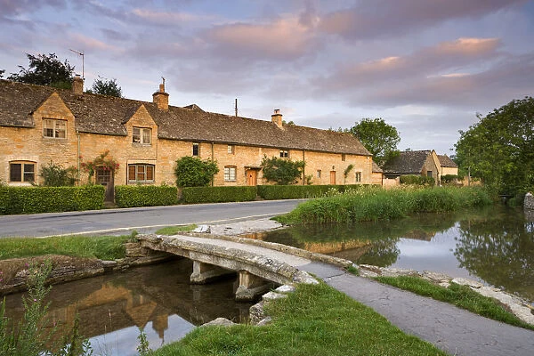 Cottages and stone footbridge in the Cotswolds village of Lower Slaughter, Gloucestershire