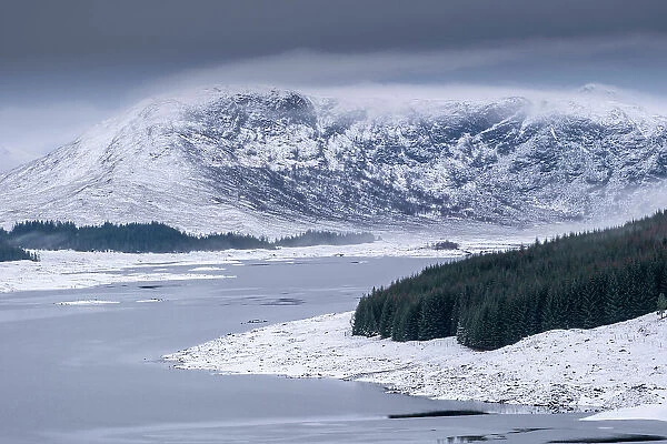 Europe, UK, Scotland, Highlands, Loch Loyne near Fort Augustus in winter. Long view of the lake with snow on the surrounding mountains. Northwest Highlands of Scotland. No people