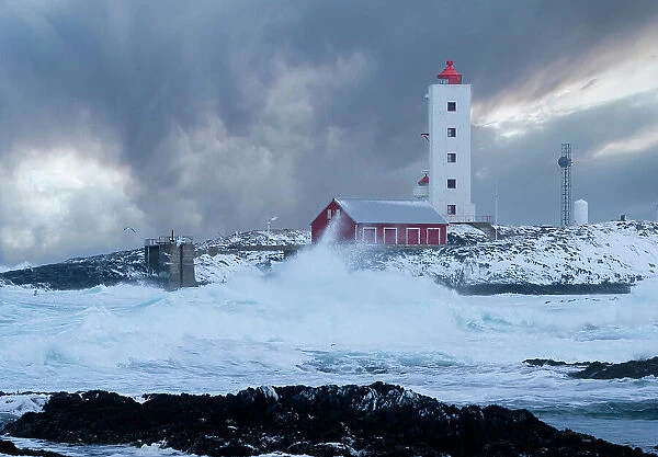 Waves spray in the cold Barents Sea, near Kjolnes lighthouse, breaking on rocks, Sandfjorden, Arctic Ocean, Varanger Peninsula, Troms og Finnmark, Norway