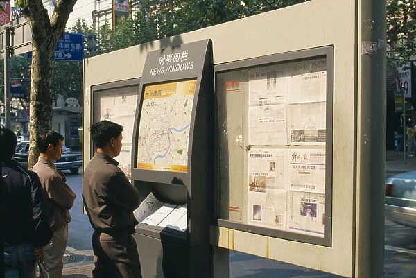 20064113. CHINA Shanghai Nanjing Road. Men reading map