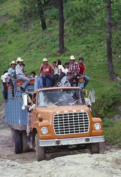 20068988. GUATEMALA Highlands Ford truck full of campesino men climbing a steep incline