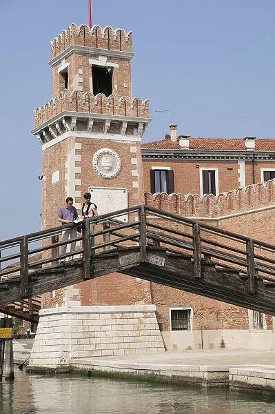 Italy, Veneto, Venice, Arsenale, bridge with couple & the walls of the Arsenale
