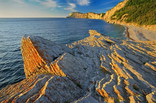 Canada, Quebec, Forillon National Park. Limestone along Atlantic shoreline at sunrise