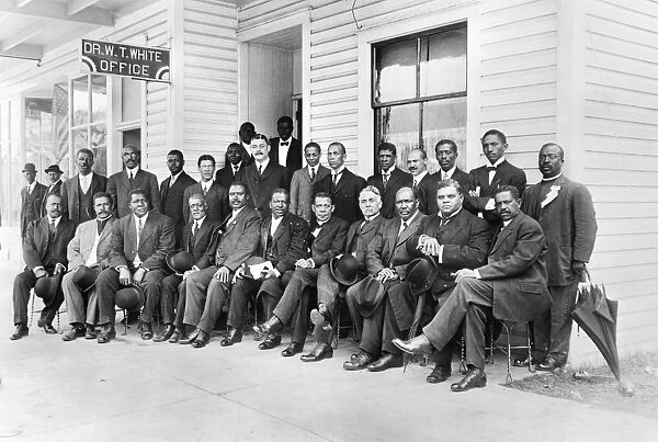 (1856-1915). American educator. Mr. Washington seated with group of men outside the office of Dr. W. T. White in Palatka, Florida. Photograph, c1915