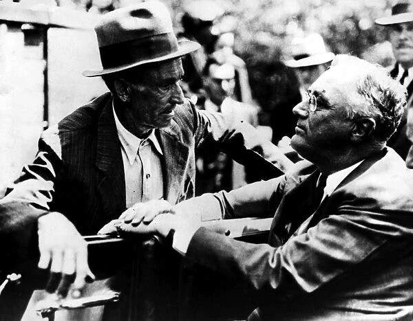 (1882-1945). 32nd President of the United States. Roosevelt talks with M. L. Perkins, a homesteader of the planned New Deal agricultural community at Arthurdale, West Virginia. Photographed 27 May 1938