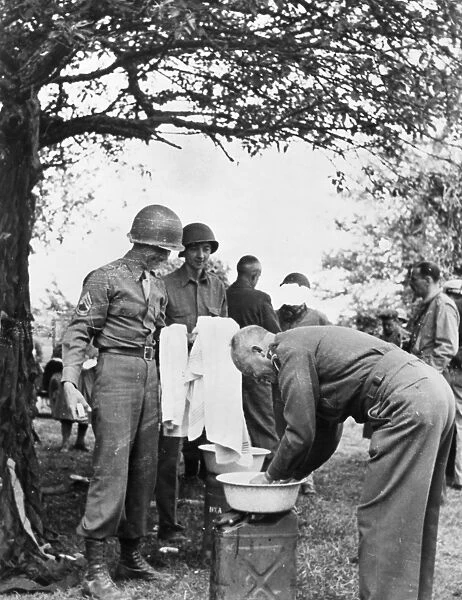 (1890-1969). 34th President of the United States. General Eisenhower washing up during inspection in the field during World War II. Scene from The True Glory, a film report of the Allied invasion of Europe, 1945
