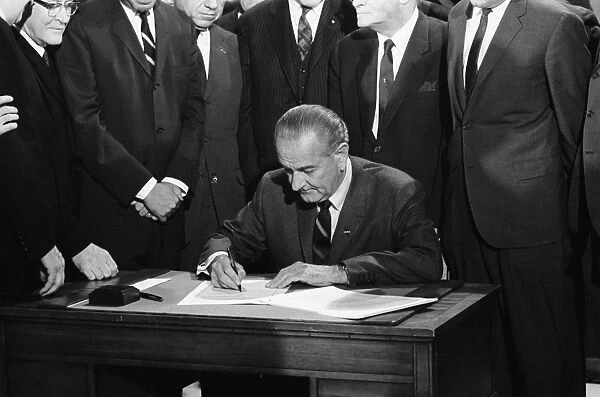 (1908-1973). 36th President of the United States. Johnson signing the Civil Rights Bill. Photographed by Warren Leffler, 11 April 1968