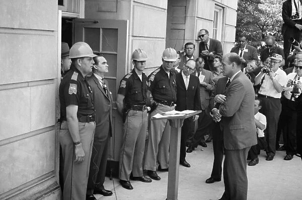 (1919-1998). American politician. Wallace (left, in suit) as governor of Alabama, attempting to block integration at the University of Alabama by standing in the doorway while being confronted by Deputy U. S. Attorney General Nicholas Katzenbach, 11 June 1963. Photographed by Warren K. Leffler