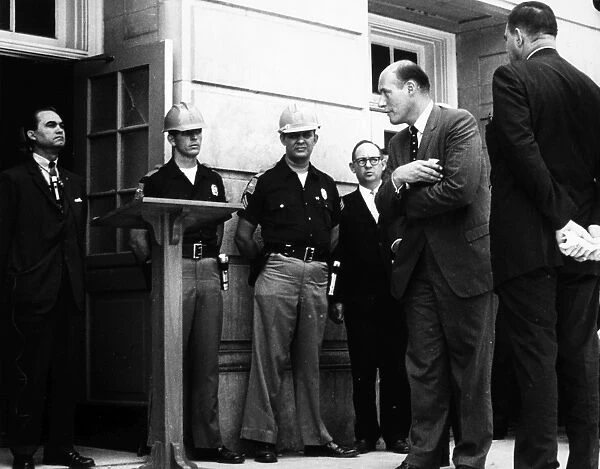 (1919-1998). American politician. Governor George Wallace fulfilling his campaign promise to stand in the schoolhouse doorway to prevent the desegregation of the University of Alabama, 11 June 1963. At right is Deputy Attorney General Nicholas Katzenbach