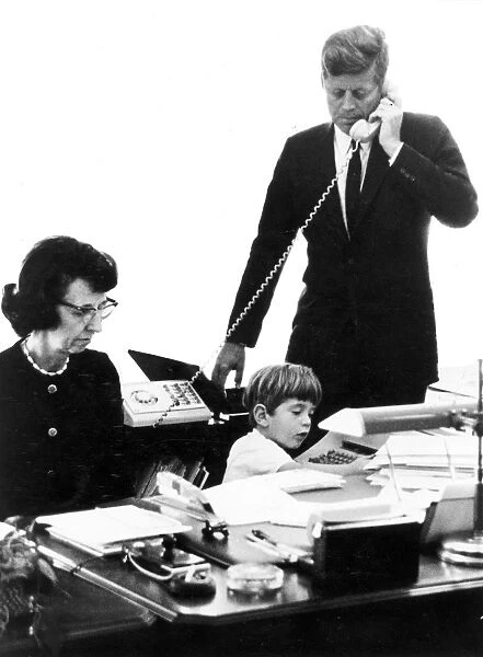 35th President of the United States. Photographed with his secretary, Evelyn Lincoln, and with his son, John F. Kennedy, Jr. in the Presidents office