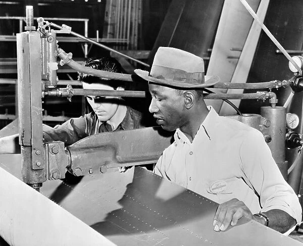 An African-American and Asian-American at work at the Douglas Aircraft factory in Los Angeles, California, during World War II