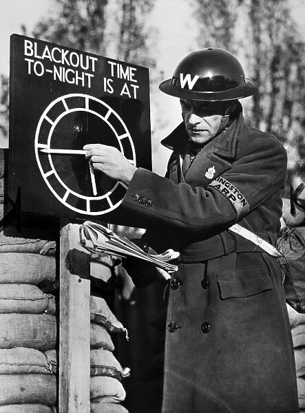 An air raid warden setting a blackout time clock indicator at an Air Raid Precautions post on the outskirts of London, England, following the outbreak of World War II, 1939