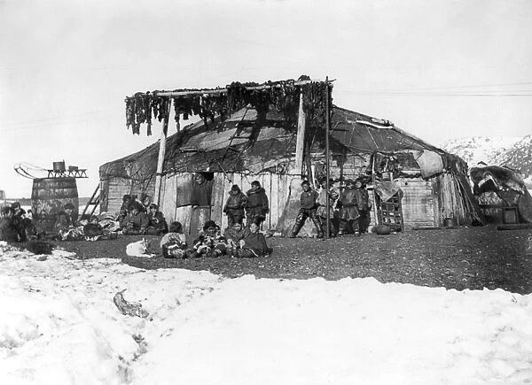 ALASKA: ESKIMOS, c1898. A group of Eskimos in front of a large house, with furs