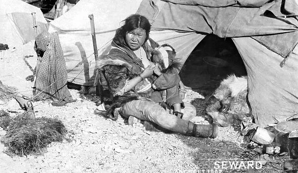 ALASKA: ESKIMOS, c1907. An Eskimo mother sitting outside a tent breast-feeding her child, Alaska