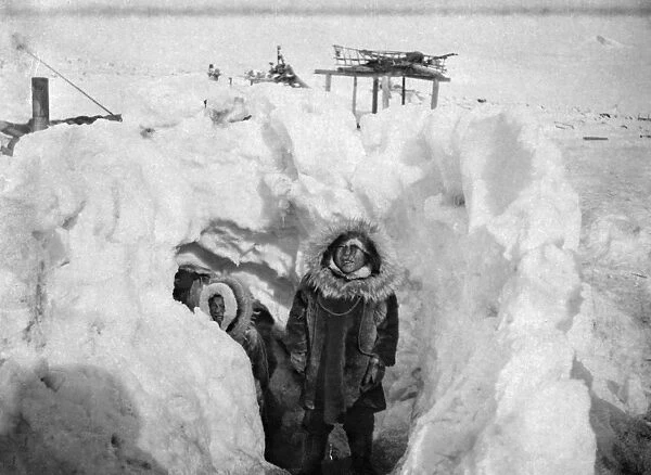 ALASKA: ESKIMOS. Two Eskimos standing at the entrance to their winter home, with