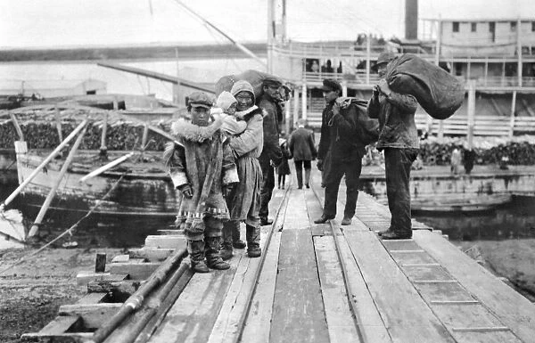 ALASKA: ESKIMOS. A group of Eskimos standing on a dock, Nome, Alaska. Photograph