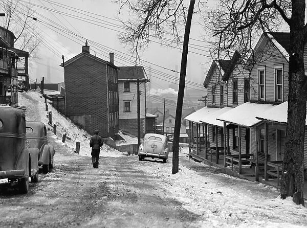ALIQUIPPA: STREET, 1941. A man walking on a snow covered street in Aliquippa, Pennsylvania