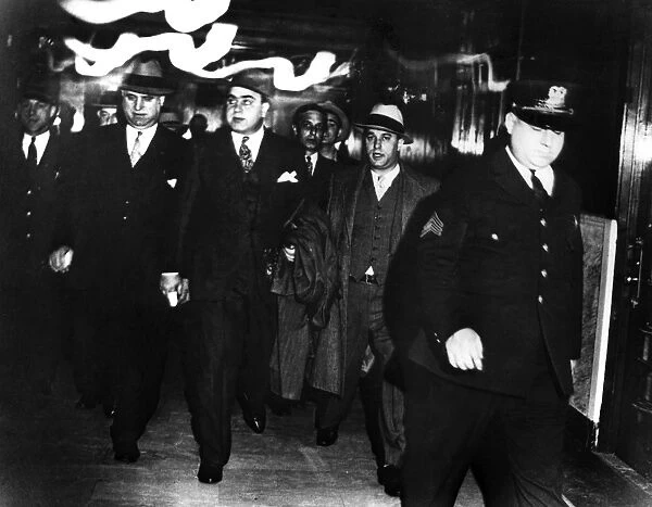 ALPHONSE CAPONE (1899-1947). American gangster. Capone (center) being escorted by federal marshals at the Chicago courthouse after being convicted for tax evasion and sentenced to prison, 1931