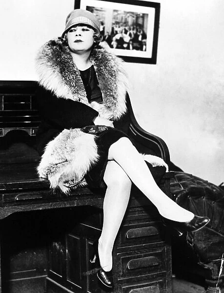 American actress. Mae West seated on a desk during the obscenity trial for her play, Sex, in 1928