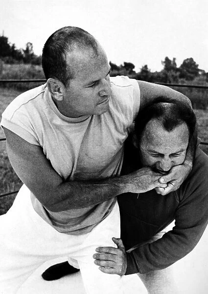 American doctor. Sheppard puts a headlock on trainer George Strickland during his wrestling career. Photographed 1969