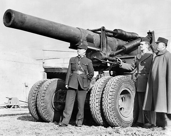 American Lieutenant Guy H. Drewry (center), in command, pointing out important features of the 8-inch howitzer to Chinese Major-General Dai-Fung King (right) and his aide-de-camp, Captain Zeit Wang (left), members of the Chinese military mission to the United States, at the Aberdeen Proving Ground, Maryland. Photograph, c1942