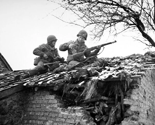 American rifleman on a rooftop in Beffe, Belgium, snipe German snipers. Photographed 7 January 1945