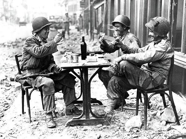 Three American soldiers at a sidewalk cafe in Paris, France, following the Allied liberation of the city, August 1944