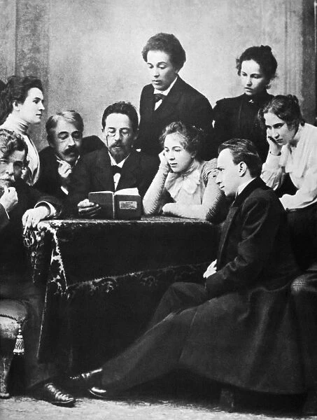 ANTON CHEKHOV (1860-1904). Anton Pavlovich Chekhov. Russian writer. Chekhov (center, with book) photographed in 1898, flanked by Konstantin Stanislavsky and Olga Knipper-Chekhova, with members of the Moscow Art Theatre
