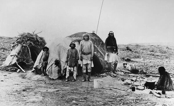 APACHE CAMP, 1882. Apache Native Americans in camp, one (right) wearing a partial