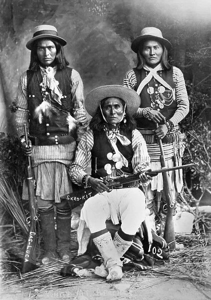 APACHE MEN, c1909. Three Apache men from the White Mountain region of Arizona, posing with rifles. Photograph, c1909