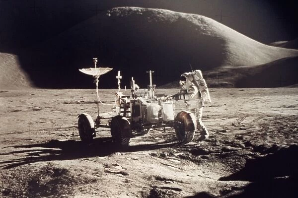 APOLLO 15, 1971. Jim Irwin standing by the lunar rover, Mount Hadley in the background