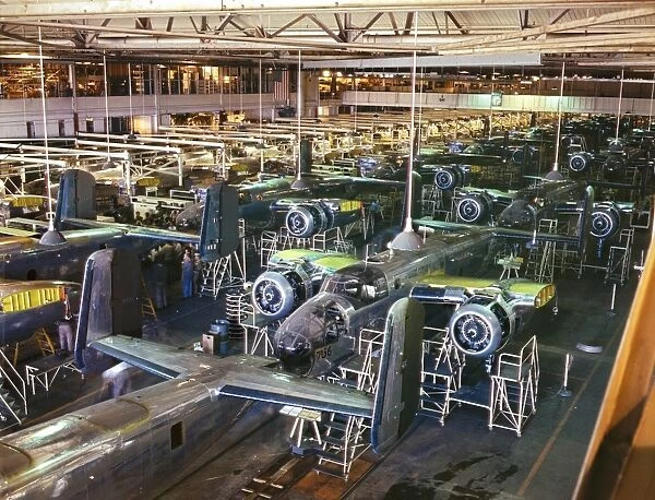 Assembly line production of B-25 bomber aircraft at the North American Aviation plant in Inglewood, California, during World War II. Photographed by Alfred T. Palmer, 1942