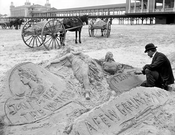 ATLANTIC CITY: THE SANDMAN. A man making sculptures and messages in the sand on the beach in Atlantic City, New Jersey. Photograph, late 19th or turn of the century
