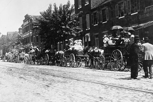 BALTIMORE: IMMIGRANTS, 1910. Immigrant families lined up on Wolfe Street in Baltimore