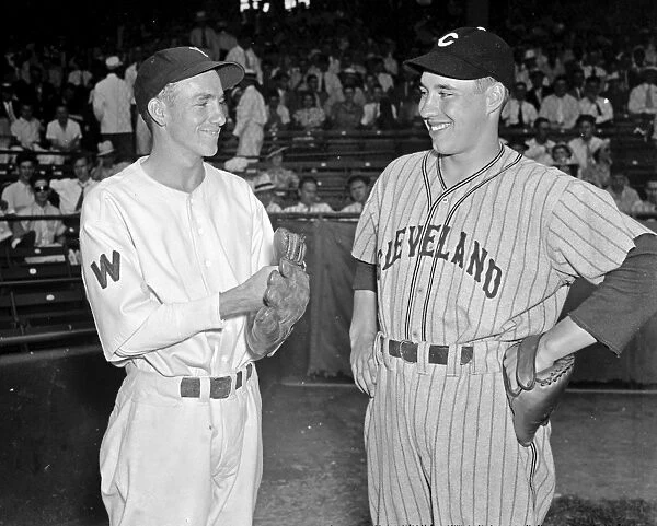 BASEBALL, 1937. Bucky Jacobs of the Washington Senators and Bob Feller of the Cleveland