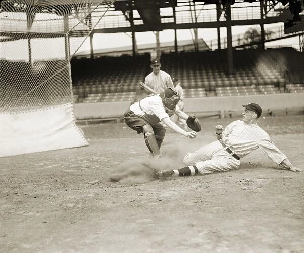 BASEBALL GAME, c1915. A runner slides into home plate while a catcher tries to tag him out during a baseball game, c1915