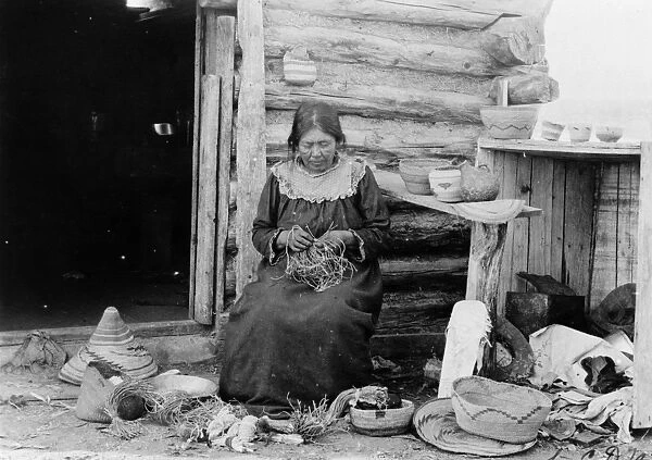BASKET WEAVING, c1904. A Native American woman weaving a basket. Photograph by C