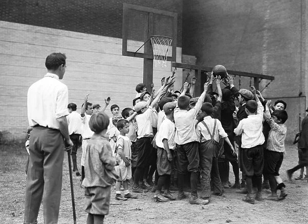 BASKETBALL, 1911. Children playing basketball at a Carnegie playground on 5th Avenue