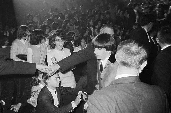 THE BEATLES, 1964. Security guards guiding Ringo Starr to the stage for the Beatles